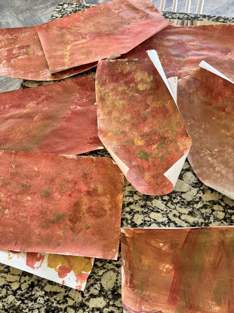 sponge painted pieces of paper on the counter drying