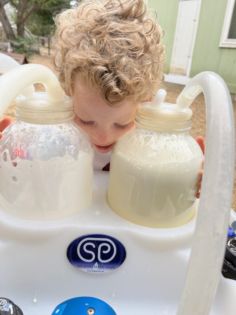 boy hugging jars of fresh cows milk